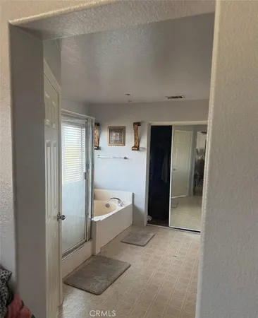 a bathroom with a tub a mirror and a shower