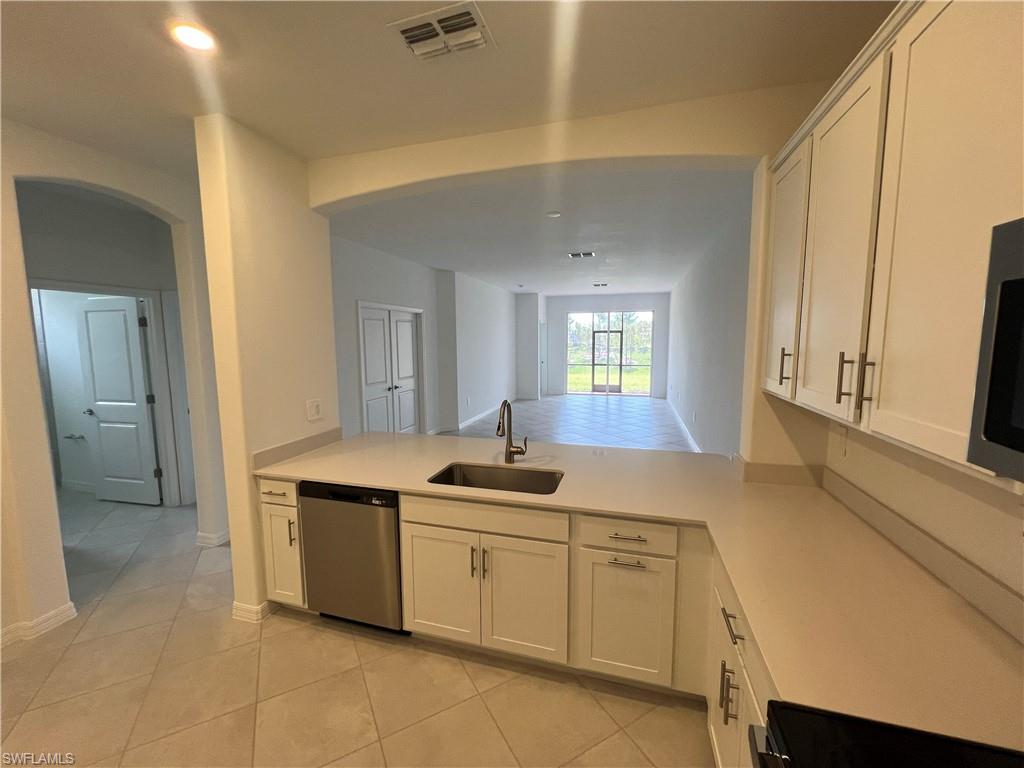 2320 Dragonfruit Way Naples, FL 34120 - Photo 7 of 33 Kitchen with light countertops, a sink, appliances with stainless steel finishes, a peninsula, and visible vents