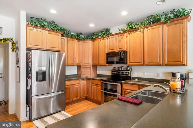 a kitchen with stainless steel appliances granite countertop a refrigerator stove and sink