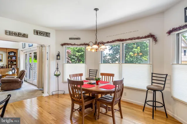 a dining room with furniture a chandelier and wooden floor