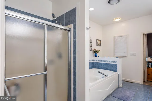 a bathroom with a tub a window and a shower