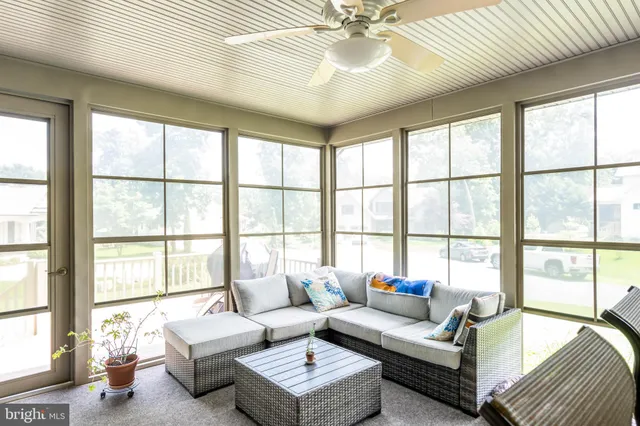 a living room with furniture and floor to ceiling windows