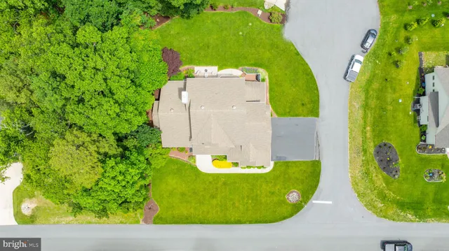 an aerial view of residential houses with outdoor space and trees