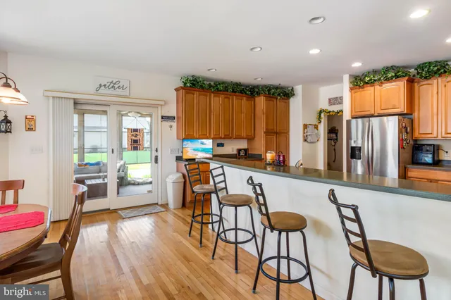 a kitchen with stainless steel appliances a table chairs refrigerator and cabinets