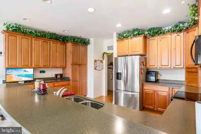 a kitchen with stainless steel appliances a refrigerator a stove a sink and a refrigerator