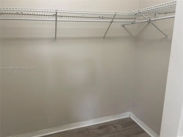 an empty room with wooden floor and mirror