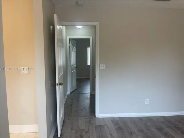 an empty room with wooden floor and a bathroom