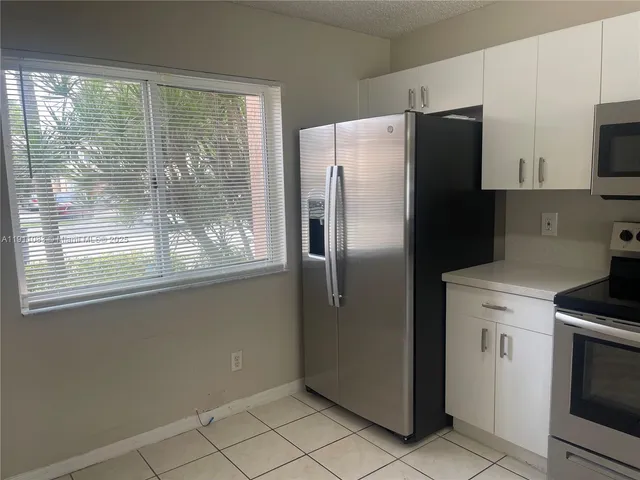 a kitchen with stainless steel appliances a refrigerator sink and microwave