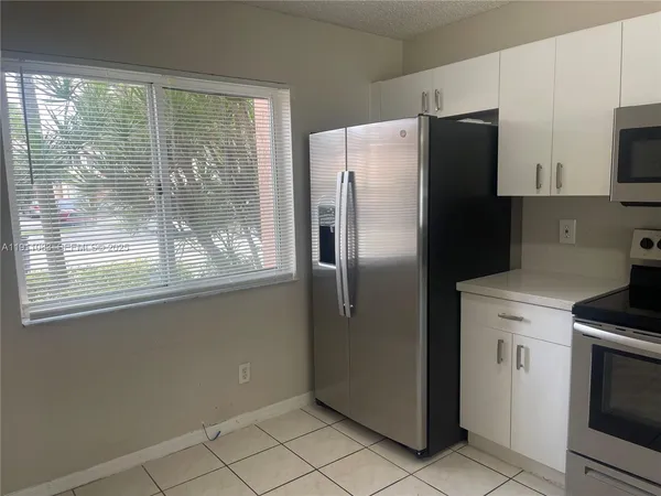 a kitchen with stainless steel appliances a refrigerator sink and microwave