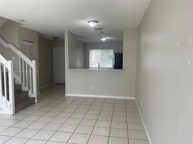 a view of a hallway with wooden floor and chandelier