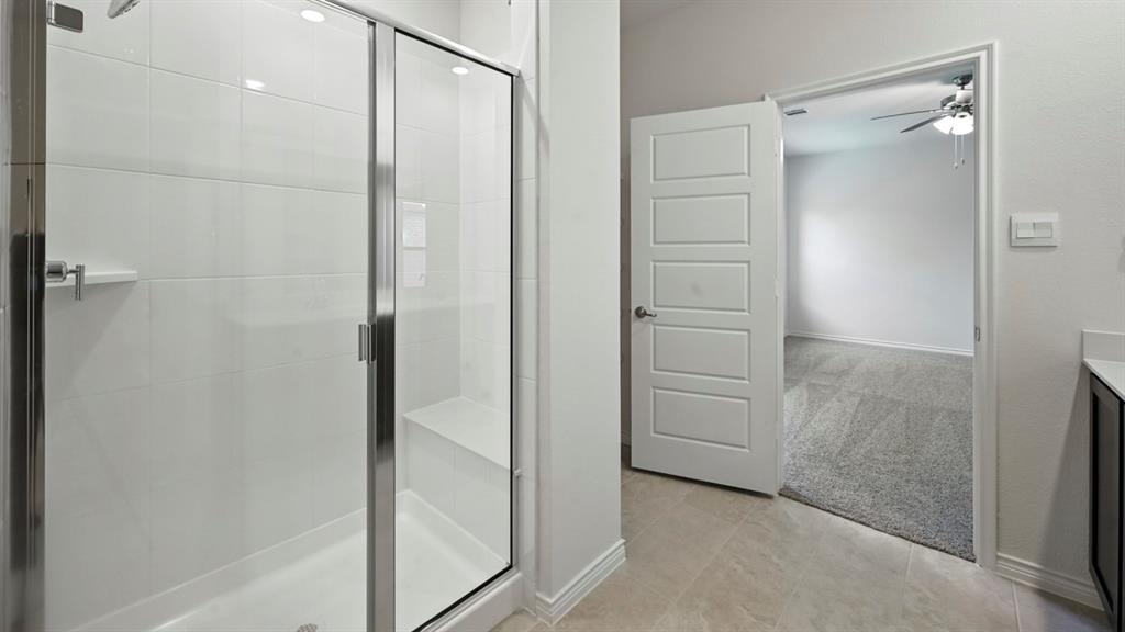 412 Carthage Street Caddo Mills, TX 75135 - Photo 24 of 32 Frameless glass shower enclosure with a built-in bench, white subway tile surround, and chrome fixtures