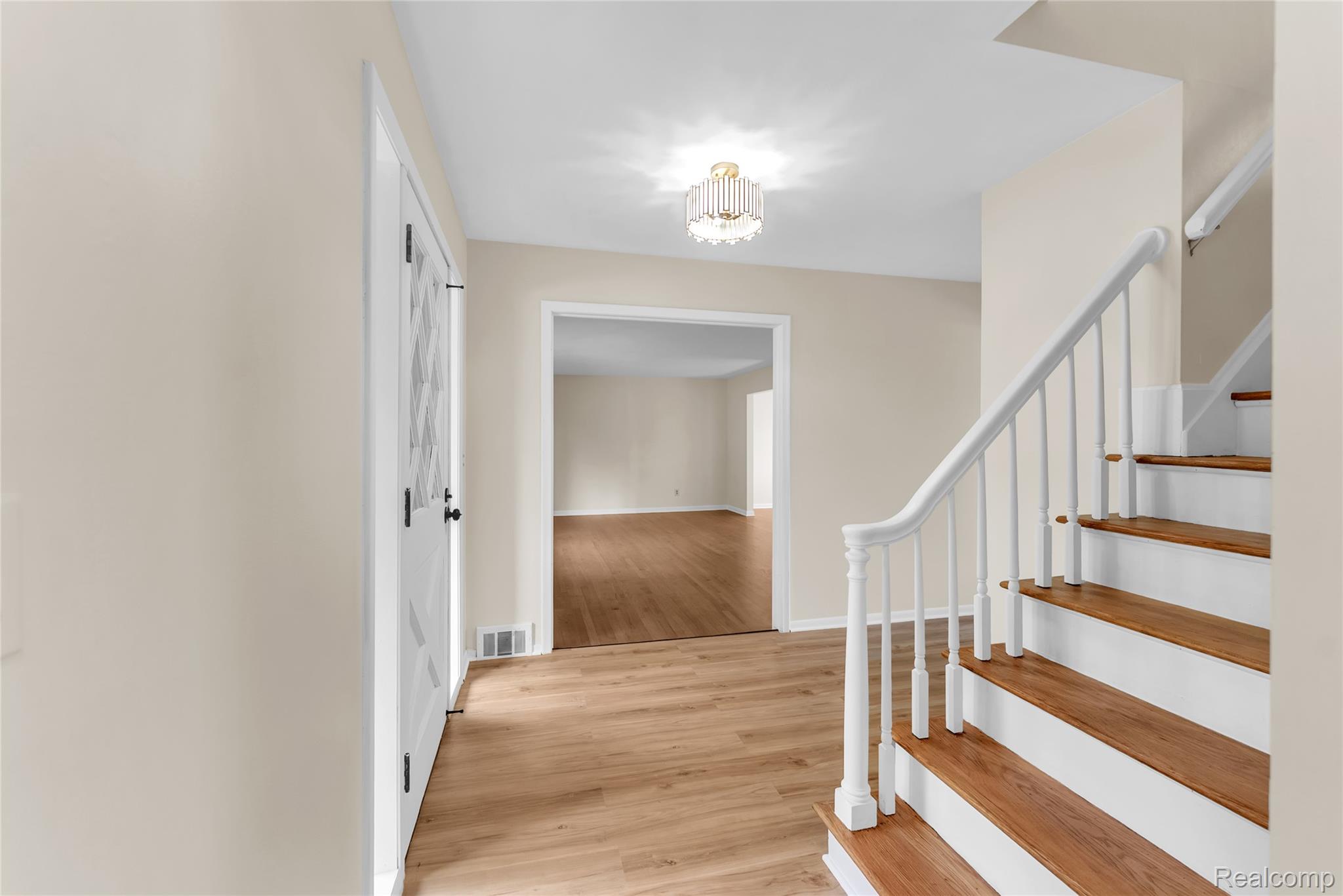 54011 Mound Road Utica, MI 48316 - Photo 5 of 27 Stairs featuring wood finished floors and a chandelier