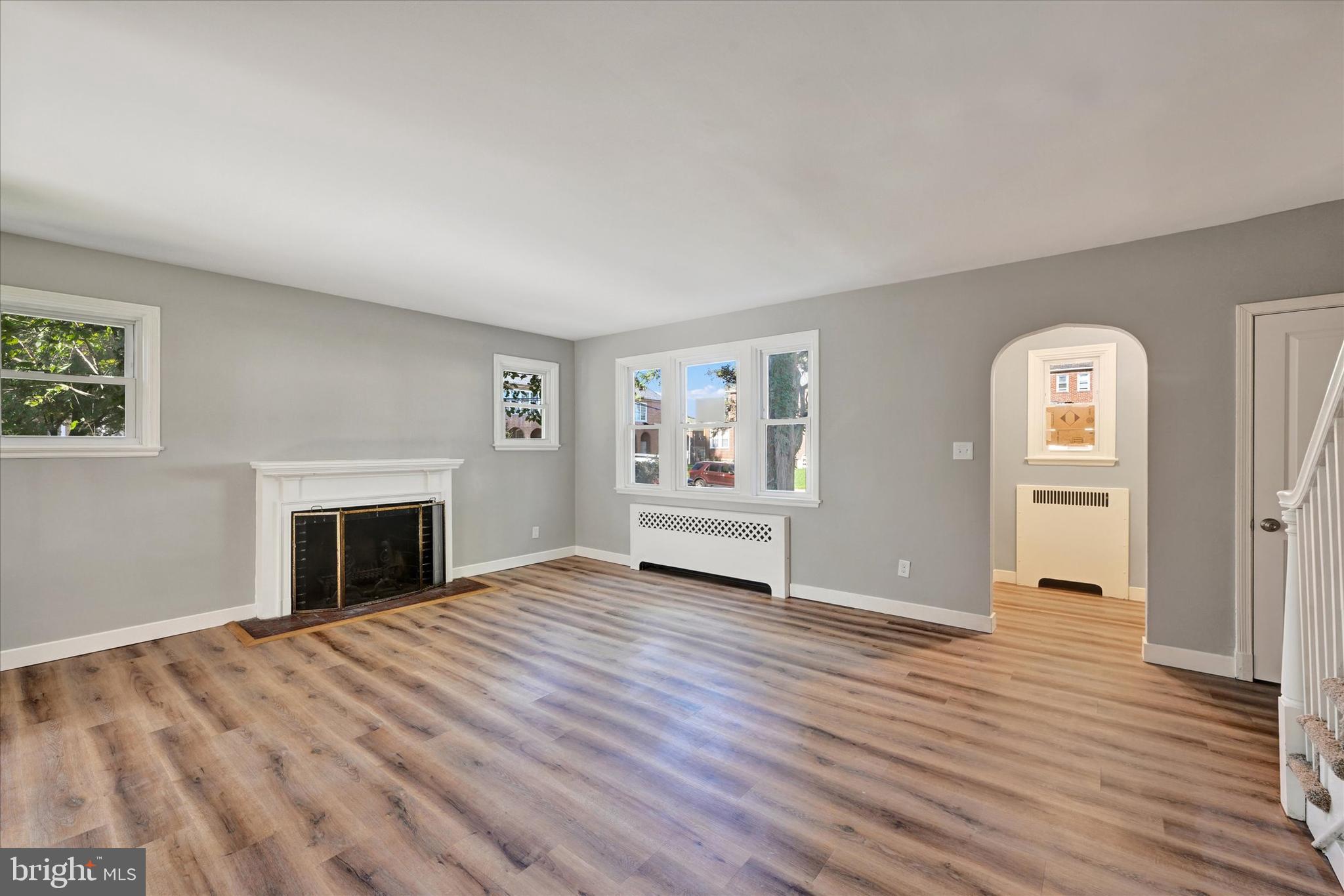 4811 Coleherne Road Baltimore, MD 21229 - Photo 3 of 28 wooden floor fireplace and windows in an empty room