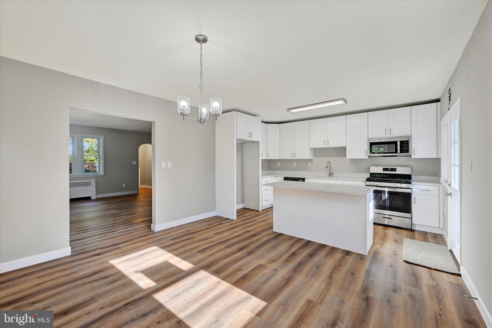 4811 Coleherne Road Baltimore, MD 21229 - Photo 8 of 28 a kitchen with white cabinets stainless steel appliances and sink