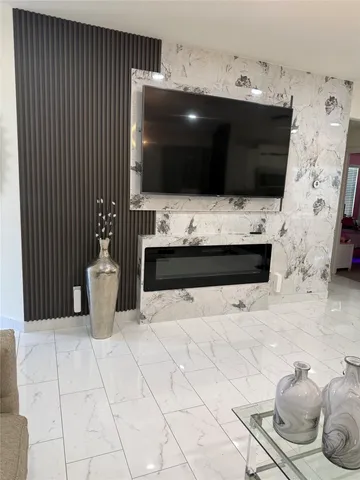 a living room with a flat screen tv and kitchen view