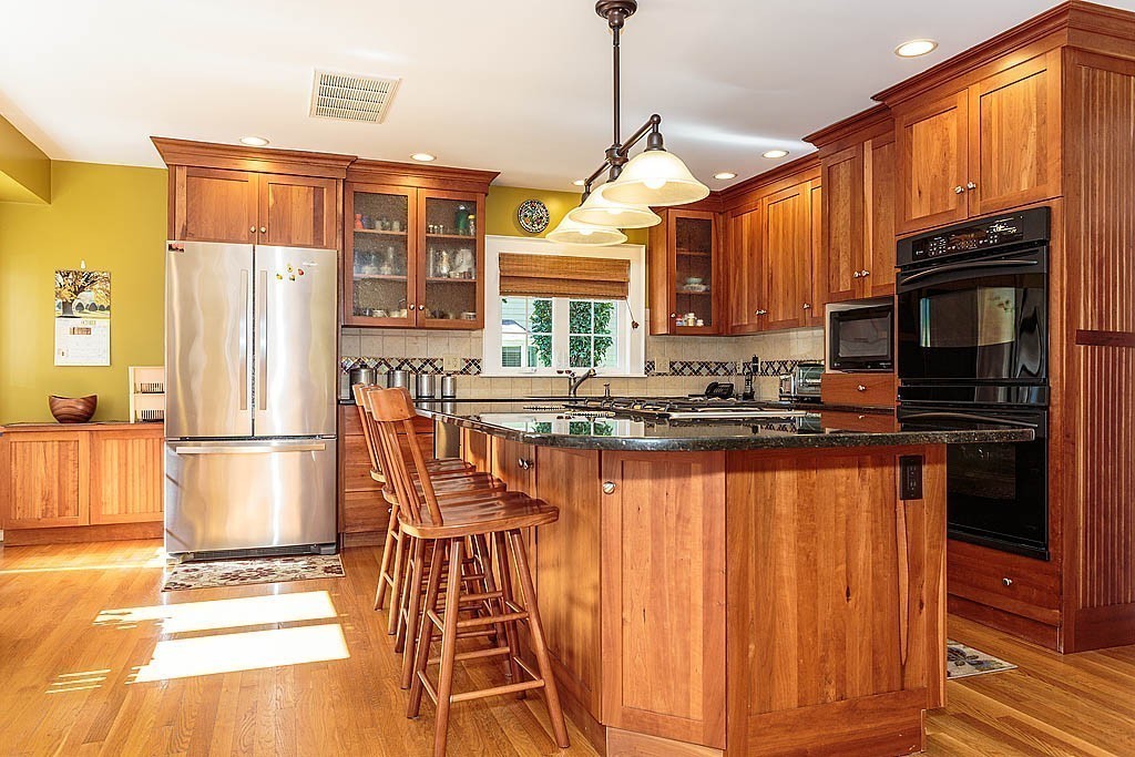 23 Jefferson Road Winchester, MA 01890 - Photo 11 of 30 a kitchen with stainless steel appliances granite countertop a refrigerator a oven a sink dishwasher and wooden cabinets with wooden floor