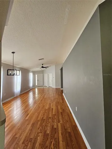 en empty room with windows and ceiling fan