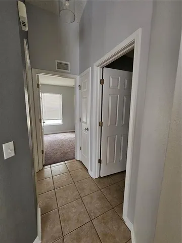 an empty room with a ceiling fan and carpet