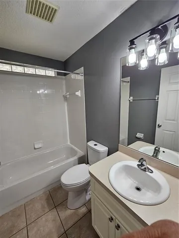 a bathroom with a glass door shower a sink and a toilet