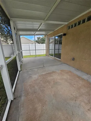 a view of a big yard with plants and large trees