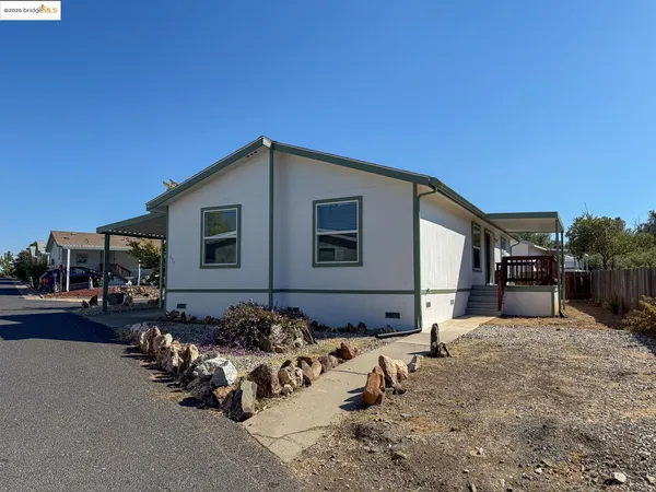 a front view of a house with cars parked