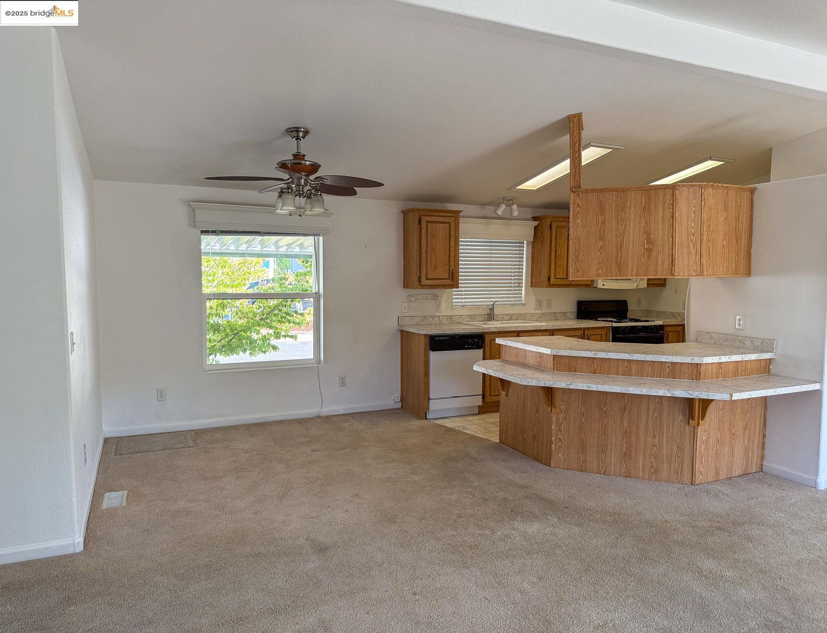 18717 Mill Villa Road, Unit 637 Jamestown, CA 95327 - Photo 6 of 19 a kitchen with stainless steel appliances a stove a sink a refrigerator a center island and a window