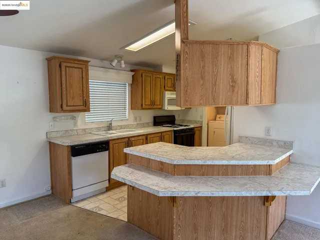 a kitchen with granite countertop a sink a counter top space and cabinets