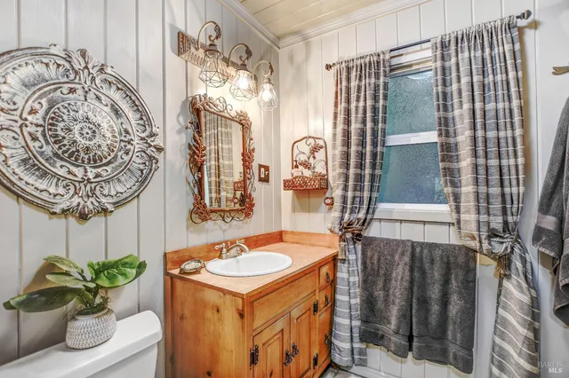 a bathroom with a sink and mirror with bathtub