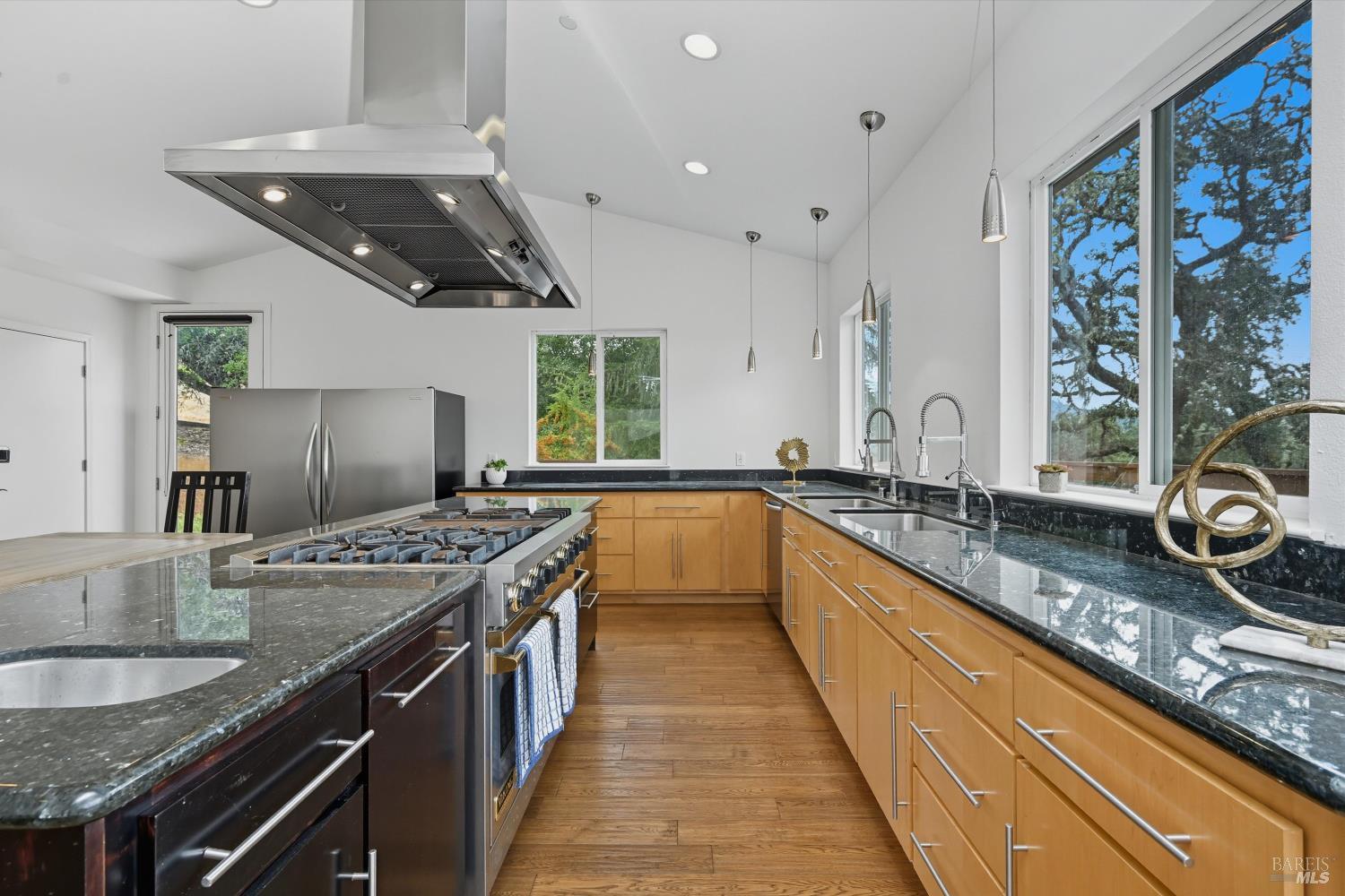 31000 Pine Mountain Road Cloverdale, CA 95425 - Photo 22 of 61 Chef’s kitchen featuring granite counters, stainless hood, generous cabinetry, and an oversized island for gathering. Well-equipped kitchen with double sinks, wet bar, and gas range beneath a lighted hood.