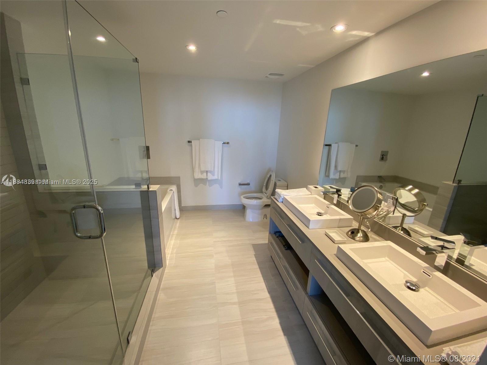 4010 South Ocean Drive, Unit R401 Hollywood, FL 33019 - Photo 15 of 20 a en suite bathroom with a double vanity sink and a mirror