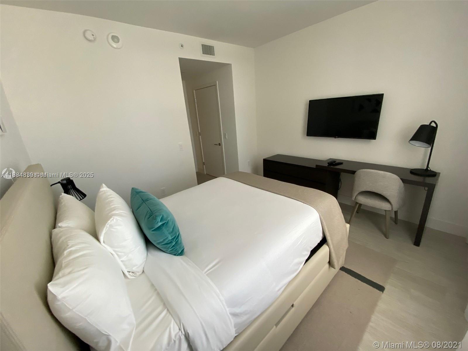 4010 South Ocean Drive, Unit R401 Hollywood, FL 33019 - Photo 18 of 20 a bedroom with a bed and a flat screen tv