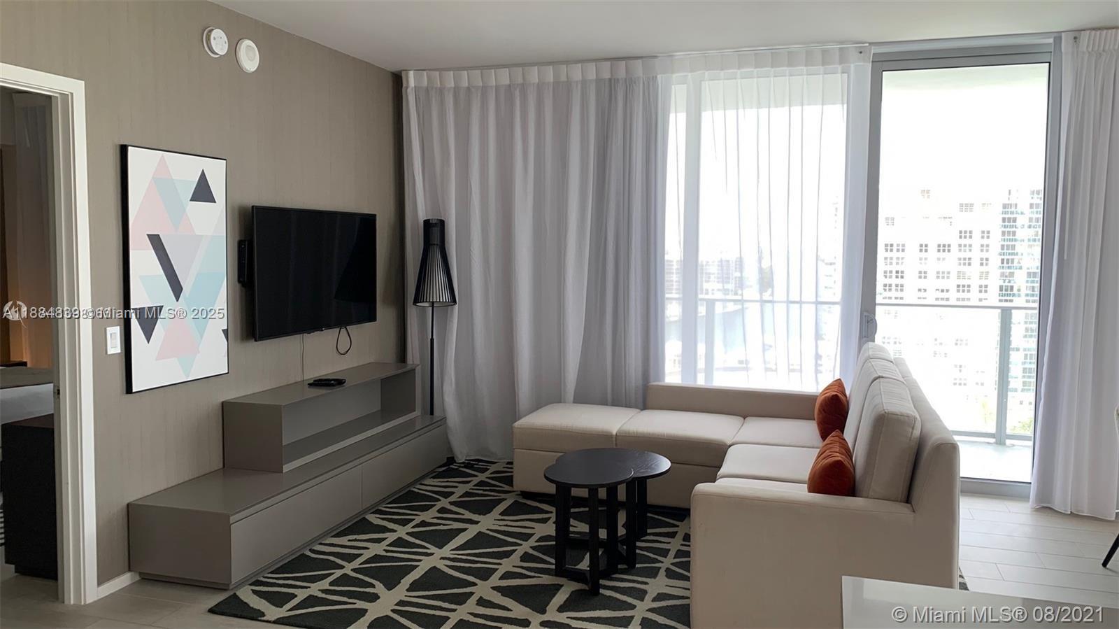 4010 South Ocean Drive, Unit R401 Hollywood, FL 33019 - Photo 7 of 20 a living room with furniture and a flat screen tv