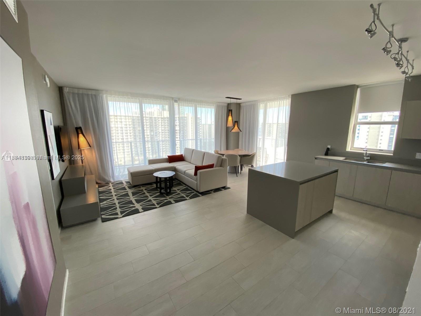 4010 South Ocean Drive, Unit R401 Hollywood, FL 33019 - Photo 10 of 20 a living room with furniture window and a flat screen tv