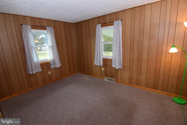 a view of an empty room with window and closet area