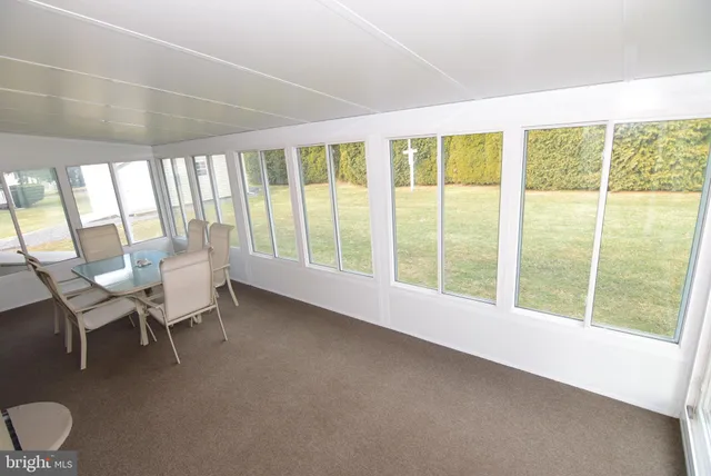 a view of a dining room with furniture large windows and wooden floor
