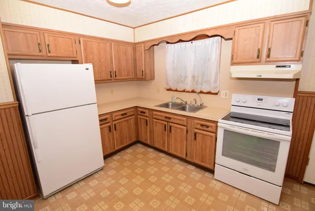 a kitchen with granite countertop a sink stainless steel appliances and cabinets