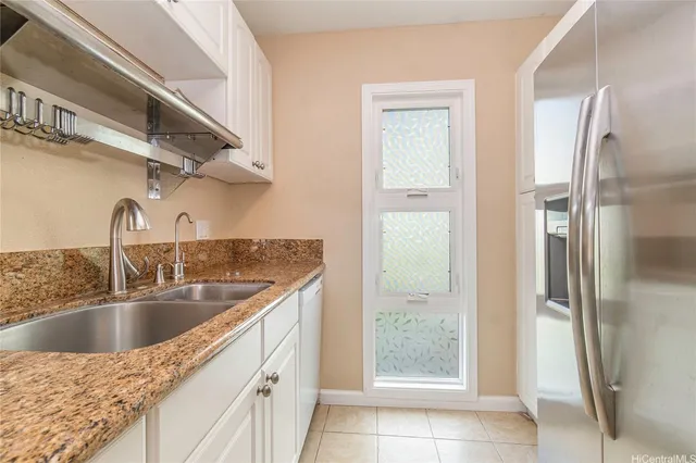 a kitchen with stainless steel appliances granite countertop a sink and a refrigerator