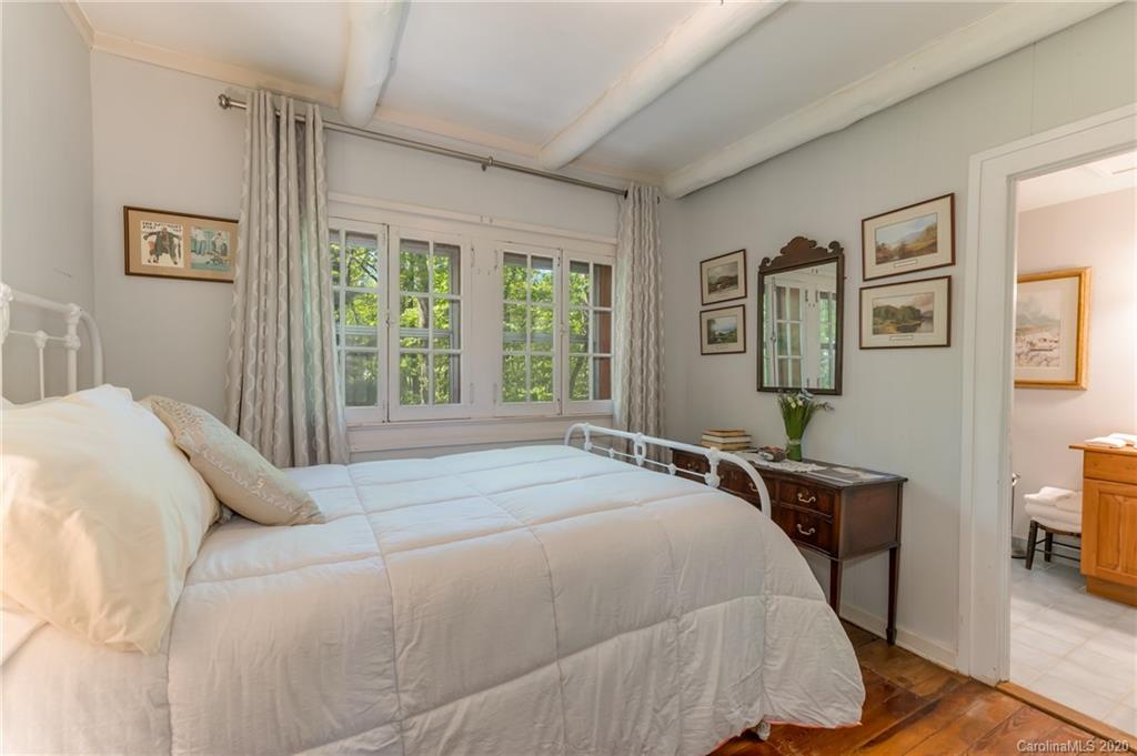 571 Wilderness Road Tryon, NC 28782 - Photo 22 of 41 a bedroom with a bed a painting and a window