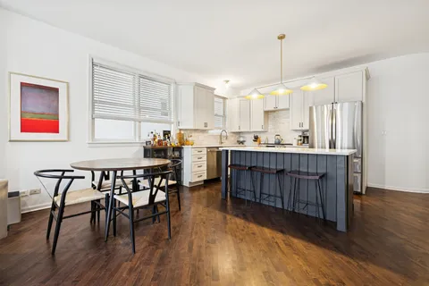 a kitchen with stainless steel appliances granite countertop wooden floors and white cabinets