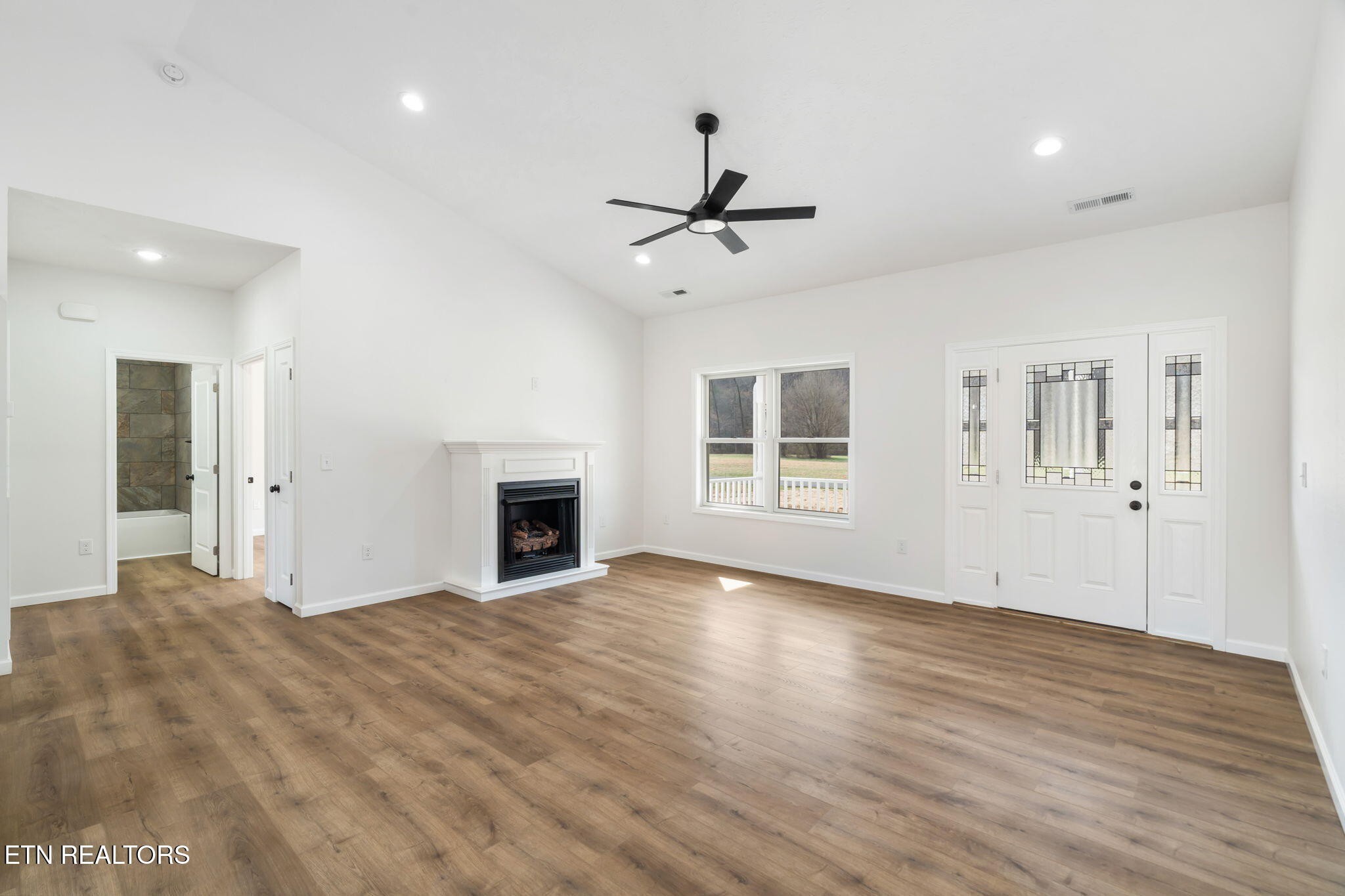 680 Kaylee Lane Del Rio, TN 37727 - Photo 25 of 41 a view of a livingroom with wooden floor a ceiling fan and windows
