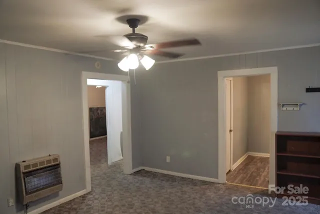 an empty room with closet and a chandelier fan