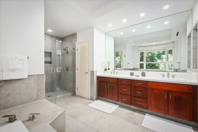 a bathroom with a tub sink shower and mirror