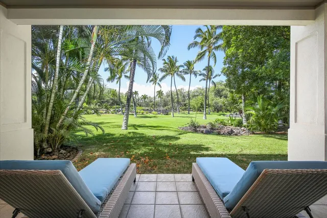 a view of backyard with green space and seating area