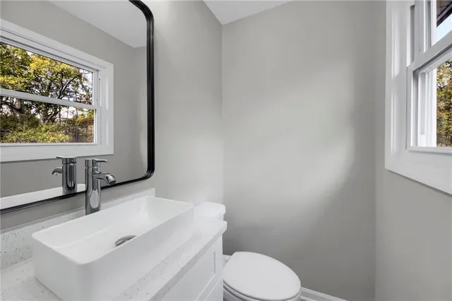 a bathroom with a sink toilet and window