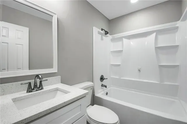a bathroom with a sink toilet vanity and shower