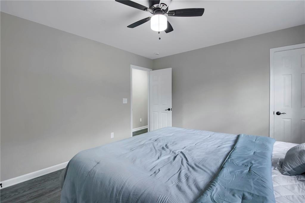 24 Echo Ridge Drive Powder Springs, GA 30127 - Photo 18 of 28 a bedroom with a bed and a chandelier