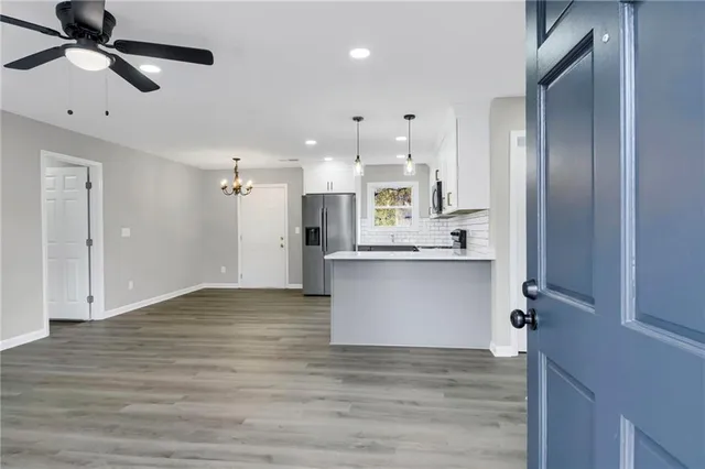 a view of large kitchen with granite countertop kitchen island a sink stainless steel appliances and cabinets