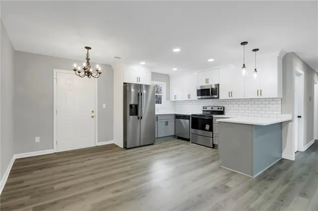 a kitchen with stainless steel appliances kitchen island granite countertop a refrigerator and a stove top oven