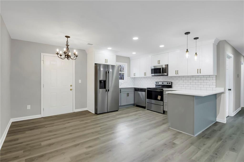 24 Echo Ridge Drive Powder Springs, GA 30127 - Photo 7 of 28 a kitchen with stainless steel appliances kitchen island granite countertop a refrigerator and a stove top oven