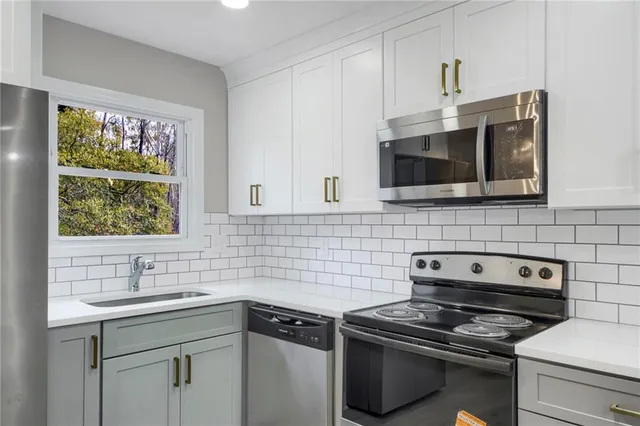 a kitchen with stainless steel appliances a stove sink microwave and cabinets